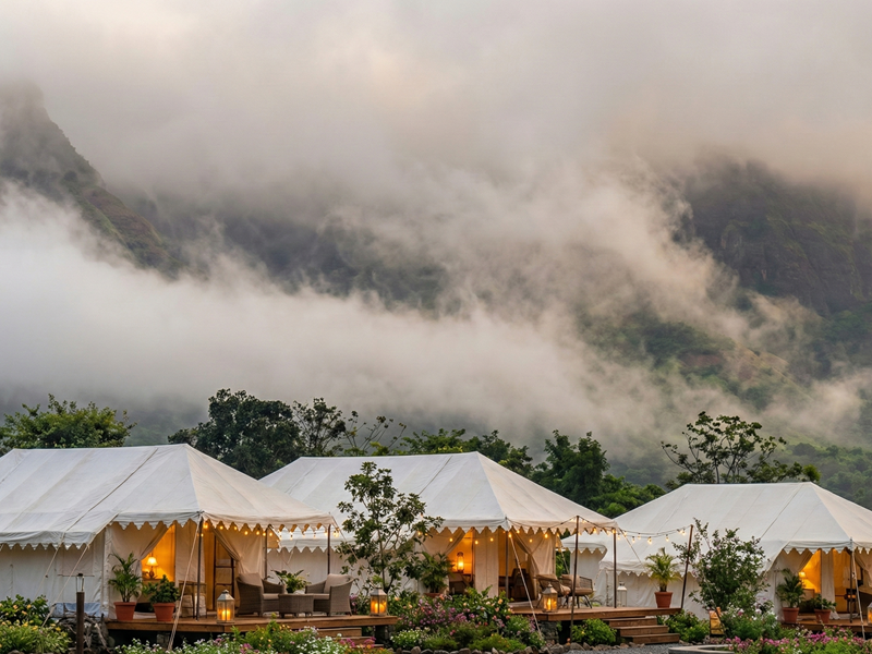 White luxury tents at the Best Resort in Bhandardara surrounded by misty mountains