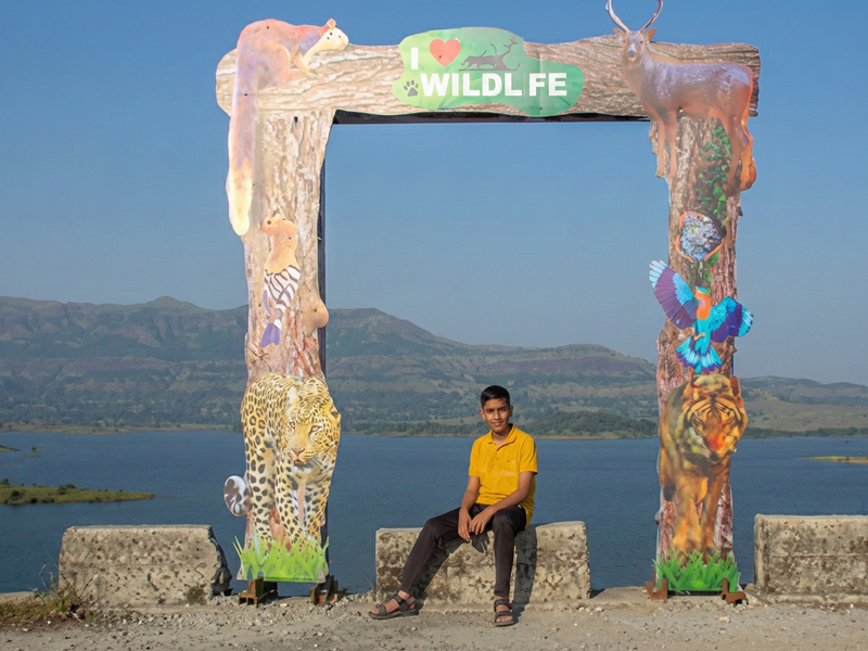 Person sitting at a scenic wildlife photo point overlooking the lake near the Best Resort in Bhandardara