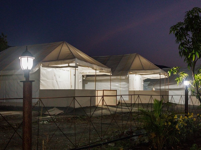 Camping in Bhandardara with tents, bonfire, mountains and starry night sky