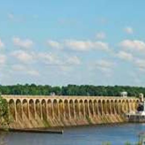 Wilson Dam surrounded by lush green hills in Bhandardara